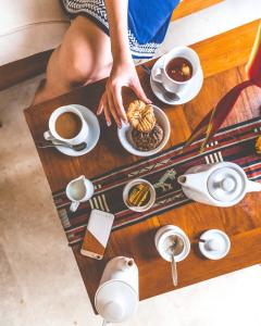 姆杜克Munduk Moding Plantation Nature Resort的一边喝咖啡一边在餐桌上吃食物的人