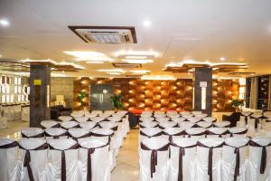 NarodaHotel Darshan SP Ring Road的宴会厅配有一排桌椅