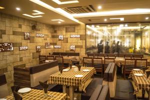 NarodaHotel Darshan SP Ring Road的一间在房间内配有桌椅的餐厅