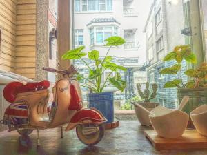 Tongluo铜锣有一种慢．慢民宿的停在有植物的窗户前的摩托车