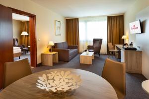 乌特普伦斯塔滕Hotel Ramada Graz的酒店客房设有桌子和客厅。