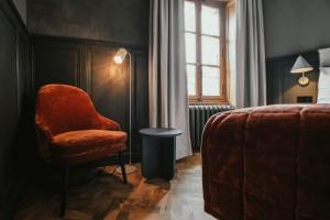 夏蒙尼-勃朗峰古斯塔维阿酒店的一间卧室配有椅子、床和窗户