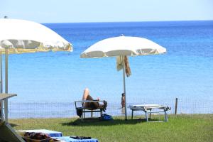 费尔蒂利亚普塔内格拉酒店的坐在海滩上一把伞下椅子上的人
