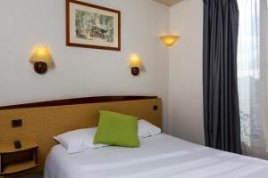 巴黎钟楼巴黎15埃菲尔铁塔酒店的一间卧室配有一张带绿色枕头的床