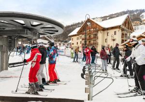 瓦卢瓦尔Résidence les chalets du Galibier Piscine Sauna Hammam WIFI的一群滑雪者乘坐滑雪缆车
