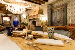 威尼斯丽都雷莱爱博蒂酒店的一张桌子,上面有白色的桌布和酒杯