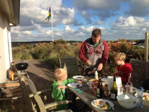 Midsland aan Zee't Zeepaardje的坐在桌子上的男人和两个孩子