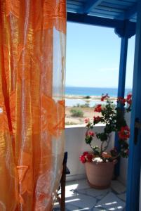 阿吉奥斯普罗科皮奥斯红湖考拉斯公寓的阳台上的橙色窗帘享有海景