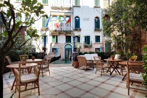 威尼斯多纳宫酒店的一座配有桌椅的庭院和一座建筑
