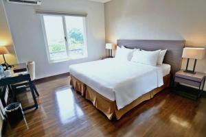 雅加达雅加达金卡莲萨马拉酒店的卧室配有一张白色大床和一张书桌