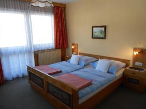 恩斯塔尔豪斯涛若号夫膳食公寓酒店的一间卧室配有一张带蓝色床单的大床