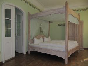 LohsaFledermausschloss的卧室配有带白色枕头的天蓬床