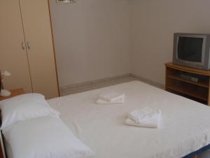 库希斯特Apartmani Anđelka的一间卧室配有一张带两条白色毛巾的床