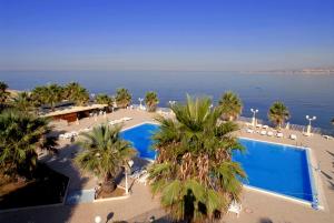 圣莱昂狄俄斯库湾宫殿酒店的享有度假村的空中景致,设有游泳池和棕榈树