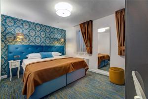 斯克拉丁斯克拉丁斯吉北区酒店的一间卧室配有一张大床和蓝色床头板