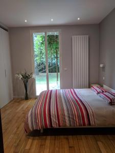 巴比松Villa Barbizon的一间卧室设有一张大床和一个窗户。