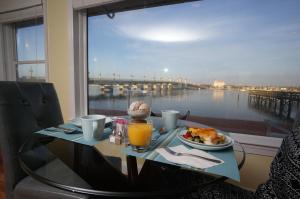 圣奥古斯丁Edgewater Inn - St. Augustine的一张桌子,上面放着一盘食物,享有海港的景色