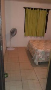 因贝Beira mar Mariluz的卧室配有1张床、风扇和窗户。