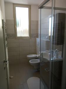 卡尼洛瑞维拉Appartamento FIORE的一间带卫生间、水槽和窗户的浴室