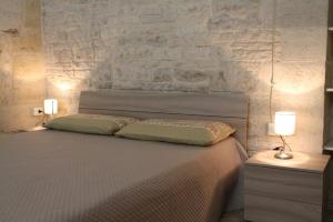 科拉托Dimora WhiteStone的一间卧室配有一张大床和两盏灯