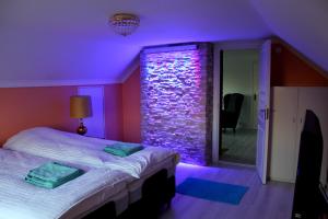 胡迪克斯瓦尔Ett hus med 3 sovrum med supersnabba internet fiberanslutningen 1000mb-100mb i Hög, 7 minuter från Hudiksvall的紫色的客房配有一张床和石墙