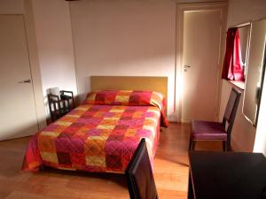 第戎夏多布里昂酒店的一间卧室配有一张带五颜六色被子的床