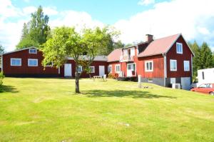 胡迪克斯瓦尔Ett hus med 3 sovrum med supersnabba internet fiberanslutningen 1000mb-100mb i Hög, 7 minuter från Hudiksvall的院子里有树的红色房子