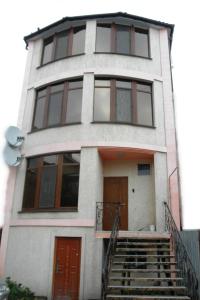 敖德萨洛丁娜酒店的白色的房子,设有棕色的门和楼梯
