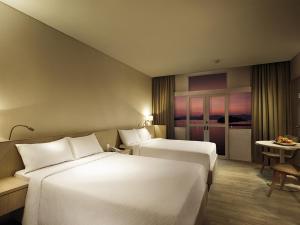 珍南海滩兰卡威世界度假村的酒店客房设有两张床和一张桌子。