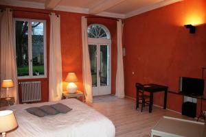 阿普特库温特酒店的一间卧室设有橙色的墙壁、一张床和电视
