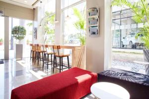 马尼拉Red Planet Manila Aseana City的一间设有酒吧、椅子和红色长凳的房间