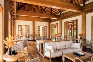琅勃拉邦Avani+ Luang Prabang Hotel的客厅配有沙发和桌椅