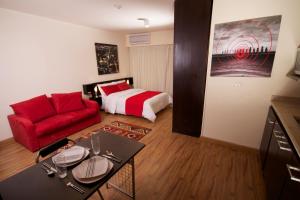 开罗NewCity Hotel & Suites的客厅配有红色的沙发和床。