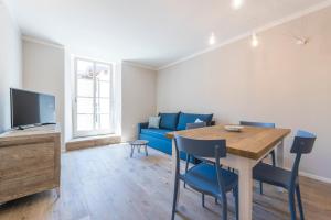 阿科Casa Tonetta Luxury Apartments的客厅配有桌子和蓝色沙发