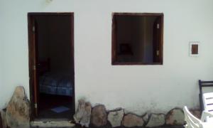 卡瓦坎特Pousada Chalés do Lago的一间房间,墙上设有门和两个窗户