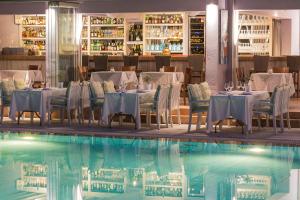 斯基亚索斯镇游泳池艺术酒店，菲莲酒店及度假村的游泳池旁的餐厅配有桌椅
