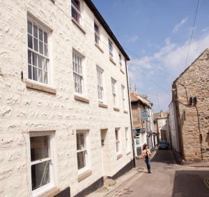 圣艾夫斯Little Dolly sea view 2 bedroom apartment, St Ives town, dog friendly的走在建筑物旁边的街道上的女人