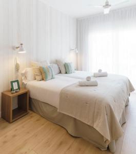 比利亚努埃瓦-赫尔特鲁BYPILLOW Mumm的白色卧室配有一张大床和两条毛巾