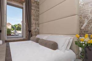扎达尔扎拉宫殿-设计旅馆的卧室配有白色的床和窗户。