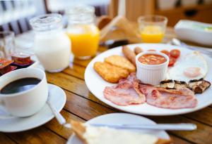 奇德尔Pymgate Lodge Hotel Manchester Airport的餐桌,早餐盘和咖啡