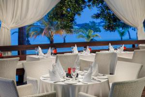 尼格瑞尔尼格瑞尔情侣度假村的一间设有白色桌椅的海洋餐厅