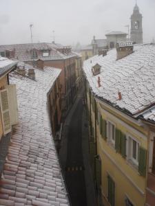 托尔托纳Albergo Residence Perosi的享有带雪盖屋顶的城市美景