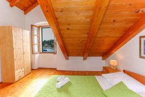 赫瓦尔Apartment Lilly with Amazing City View的一间卧室设有绿色的床和木制天花板