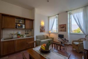 贝拉吉奥波齐奥迪贝拉焦迪公寓式酒店的厨房以及带桌子的客厅。