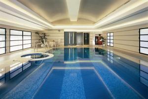米兰Hotel Principe Di Savoia - Dorchester Collection的一座带游泳池的大楼内的大型游泳池