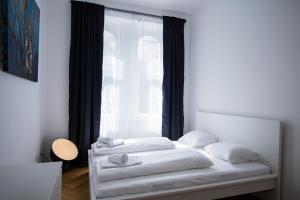 维也纳Porzellangarten Apartment I contactless Check-In的一间卧室配有一张带白色床单的床和一扇窗户。