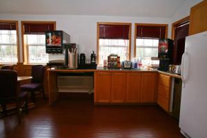 姊妹城Sisters Inn & Suites的厨房配有木制橱柜和冰箱。