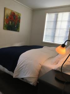 埃格尔松Ellingsens Apartment Egersund的一间卧室配有一张床和一张带台灯的桌子