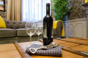 布达佩斯Viktoria Luxury Apartment的桌子上放有一瓶葡萄酒和两杯酒