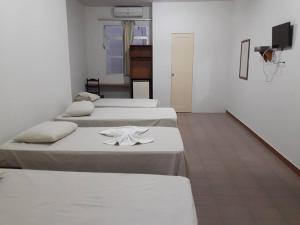 ItabaianaHotel Danubio的一间设有四张床的客房,并备有毛巾